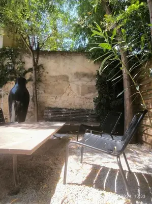 a black chair sitting next to a table and a vase at Magnifique maison de ville 6personnes , piscine et garage in Aix-en-Provence
