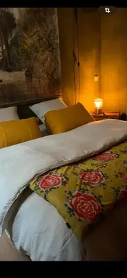 a bed with a yellow blanket with flowers on it at Chambre style balinais in Aix-en-Provence