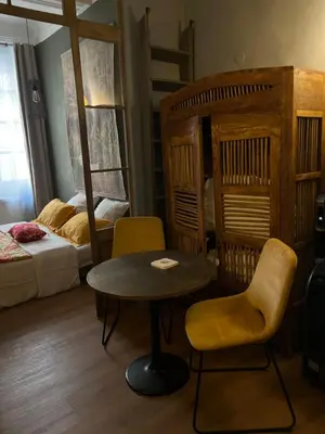 a room with a table and chairs and a bed at Chambre style balinais in Aix-en-Provence