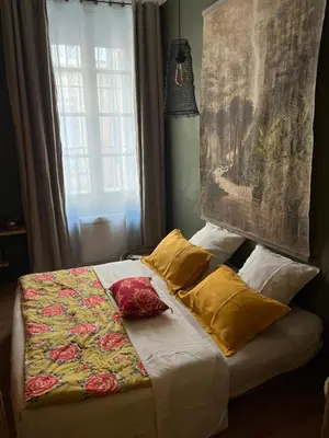 a bed with a blanket and pillows on it at Chambre style balinais in Aix-en-Provence