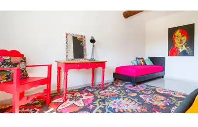 a living room with a red table and a red chair at Ritournelle en Provence 19 personnes 4 étoiles in Pernes-les-Fontaines