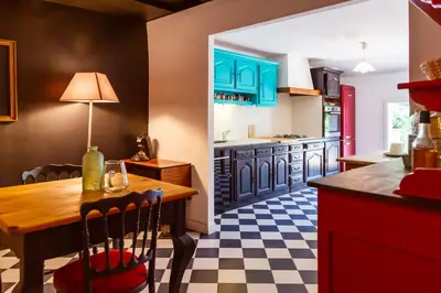 a kitchen with blue cabinets and a wooden table at Ritournelle en Provence 19 personnes 4 étoiles in Pernes-les-Fontaines