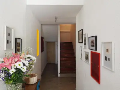 a hallway with flowers and pictures on the walls at Ritournelle en Provence 19 personnes 4 étoiles in Pernes-les-Fontaines