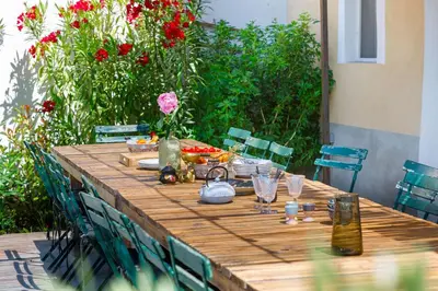 a wooden table with plates and wine glasses on it at Ritournelle en Provence 19 personnes 4 étoiles in Pernes-les-Fontaines