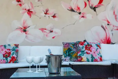 a living room with a white couch with flowers on the wall at Ritournelle en Provence 19 personnes 4 étoiles in Pernes-les-Fontaines