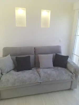 a couch with pillows sitting in a living room at 2 Voyageurs - 1 Lit - Proche de toutes commodités in Peyrolles-en-Provence