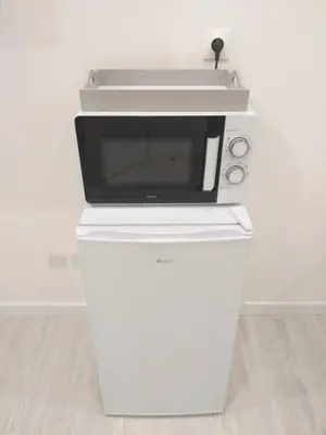 a microwave sitting on top of a white refrigerator at 2 Voyageurs - 1 Lit - Proche de toutes commodités in Peyrolles-en-Provence