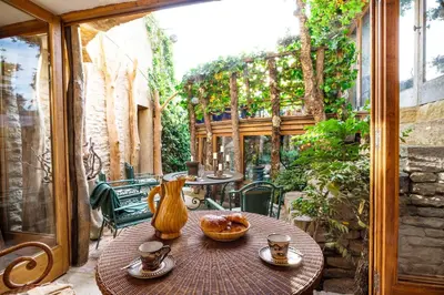 an outdoor table with a vase on a patio at La maison de la piscine in Goult