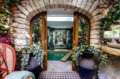 an archway with vases in front of a door at La maison de la piscine in Goult