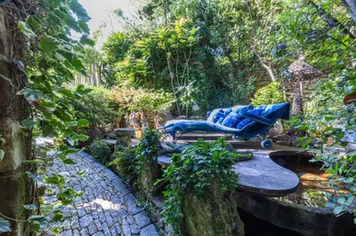 a garden with a stroller and chairs on a patio at La maison de la piscine in Goult