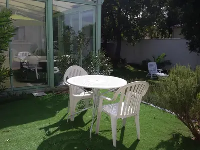 a white table and two chairs in a garden at Nice flat with jacuzzi and garden in Velleron