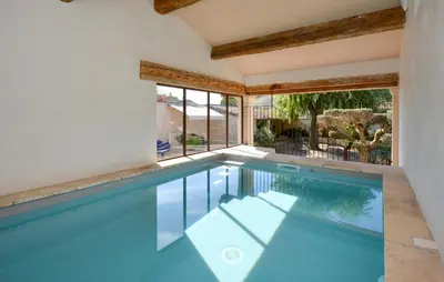 an indoor swimming pool with blue water in a house at Stunning Home In Noves With Wifi in Noves