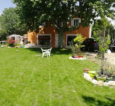 a yard with a white chair and a tree at Maison Aix en Provence et grand jardin in Aix-en-Provence