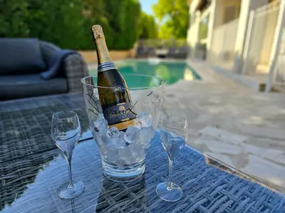 a bottle of wine in a bucket with glasses on a table at Paradise Corner in LʼIsle-sur-la-Sorgue