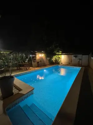a large blue swimming pool at night at Grand studio avec piscine au coeur du village in Le Puy-Sainte-Réparade