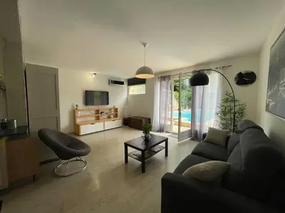 a living room with a couch and a table at Grand studio avec piscine au coeur du village in Le Puy-Sainte-Réparade