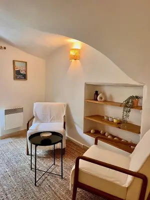 a living room with a chair and a table at coeur du Luberon in Lourmarin