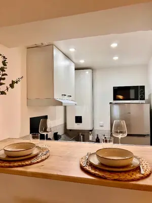 a kitchen with two plates and wine glasses on a counter at coeur du Luberon in Lourmarin