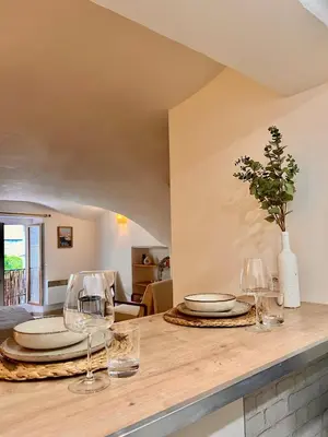 a kitchen counter with plates and wine glasses on it at coeur du Luberon in Lourmarin