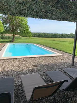 a bedroom with a bed and two chairs and a mirror at Mas des Lubières in Saint-Rémy-de-Provence