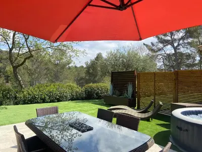 a patio with a table and a red umbrella at Studio climatisé - Terrasse, Plancha, Fibre in Aix-en-Provence