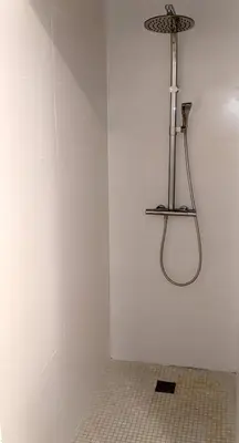 a shower in the corner of a bathroom with a tile floor at Chambre Voltaire ou Chambre Beckett, terrasse en bord de Sorgue in Le Thor
