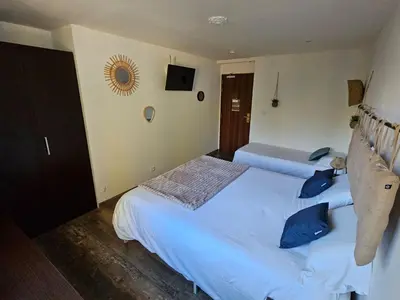 two beds in a hotel room with blue pillows at La madone in La Tour-dʼAigues