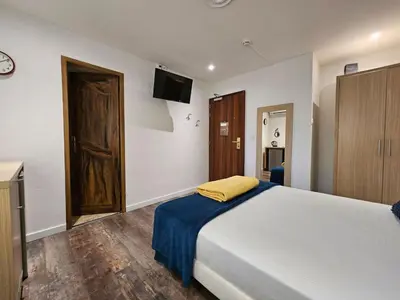 a bedroom with a bed and a tv on the wall at La madone in La Tour-dʼAigues