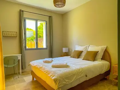 a bedroom with a large bed with a window at Villa Mathilde, un meublé de tourisme 3 étoiles au cœur de Goult in Goult