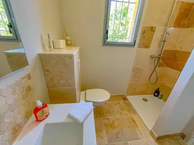 a bathroom with a shower and a toilet and a sink at Villa Mathilde, un meublé de tourisme 3 étoiles au cœur de Goult in Goult