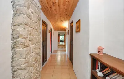 a hallway with a stone wall and a wooden ceiling at Stunning Home In Vacheres in Vachères