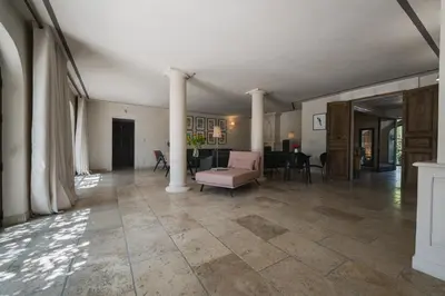 a living room with columns and a pink couch at Mas Naste in Eygalières