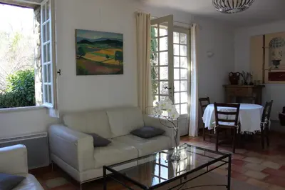 a living room with a couch and a glass table at La Maison des Roches in Gordes
