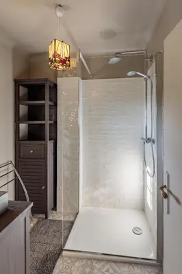 a shower with a glass door in a bathroom at La Maison des Roches in Gordes