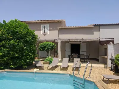 a bedroom with a large bed with white sheets and pillows at Un Coin de Provence in LʼIsle-sur-la-Sorgue