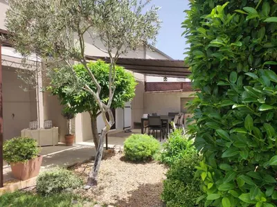 a bedroom with a bed with two pillows and a desk at Un Coin de Provence in LʼIsle-sur-la-Sorgue