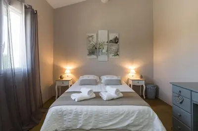 a bedroom with a large bed with towels on it at Un Coin de Provence in LʼIsle-sur-la-Sorgue