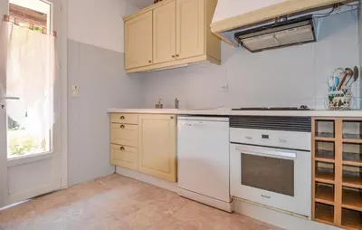 a kitchen with white appliances and a window at Maison de Village avec jardin dans Centre historique in Eyguières