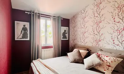 a bedroom with a bed with red walls and a window at Le clos de l’artichaut in Eyguières