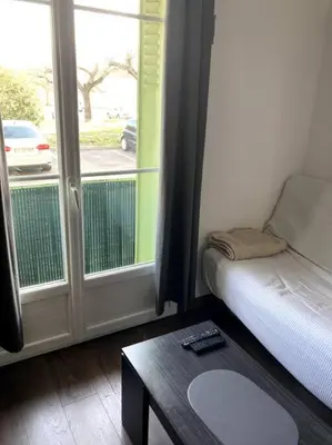 a room with a bed and a table and a window at Appartement entier au RDC in Salon-de-Provence
