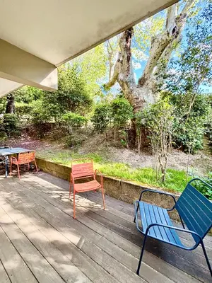 a deck with two chairs and a table and a tree at Magnifique T2 avec Terrasse in Aix-en-Provence