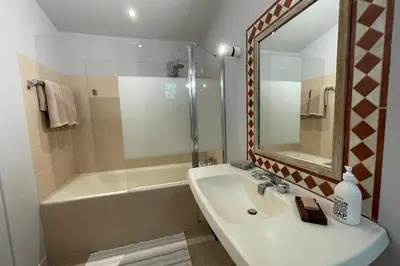 a bathroom with a sink and a shower and a mirror at La Maison Maupas in Ménerbes