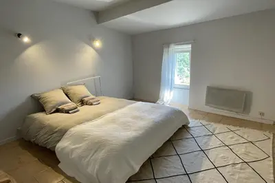 a large bed in a room with a window at La Maison Maupas in Ménerbes