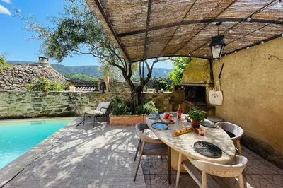 a patio with a table and chairs next to a pool at La Maison Maupas in Ménerbes