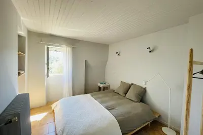 a bedroom with a bed and a window at La Maison Maupas in Ménerbes