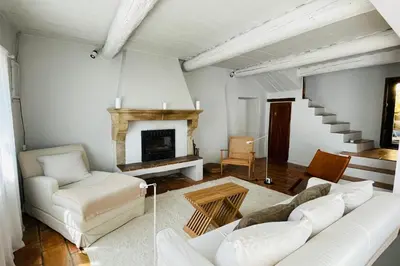 a living room with a white couch and a fireplace at La Maison Maupas in Ménerbes