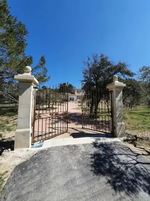 a gate to a driveway with at Havre de paix au bord des Alpilles in Eyguières