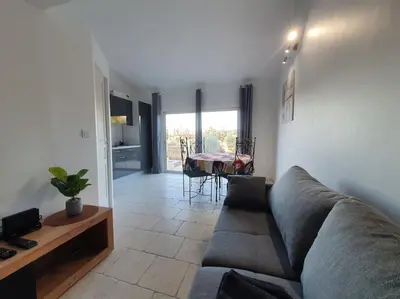 a living room with a couch and a table at Havre de paix au bord des Alpilles in Eyguières