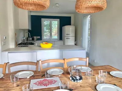 a dining room table with chairs and a kitchen at Hope, villa à Aix en Provence in Aix-en-Provence