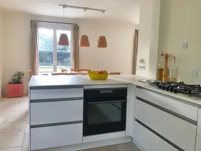 a kitchen with white cabinets and a blue wall at Hope, villa à Aix en Provence in Aix-en-Provence